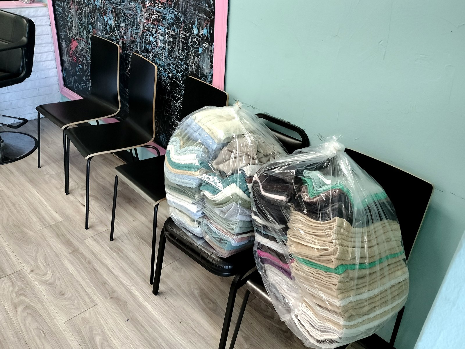 Barbershop capes and towels folded and ready to go back to the shop