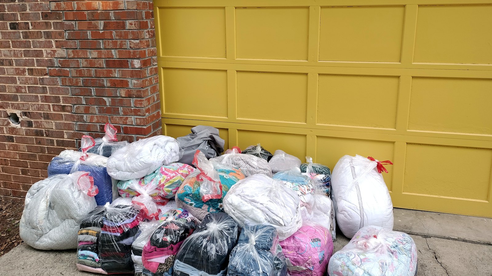Several full laundry bags waiting on a doorstep for a Timeout Services pickup